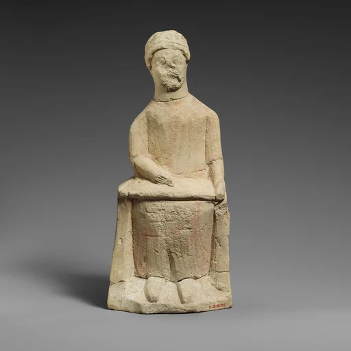 Limestone statuette of a seated beardless male votary writing on a scroll