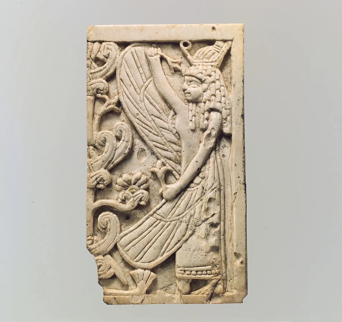 Furniture plaque carved in relief with a winged female figure and a “sacred tree” — Unknown