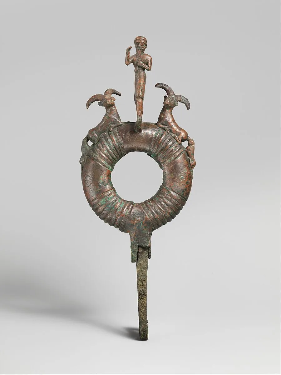 Top of standard with male figure and flanking ibexes attacked by dogs — Unknown
