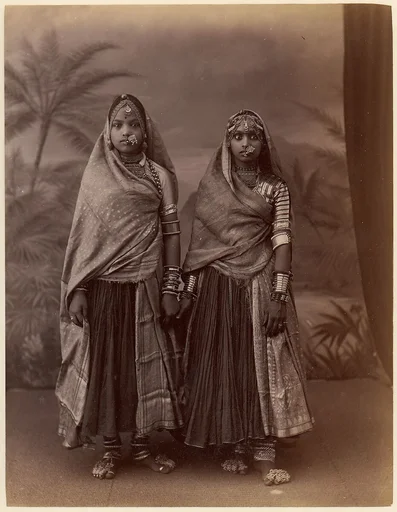 [Two Hindu Women in Elaborate Jewelry, Before Studio Backdrop with Palm Trees]