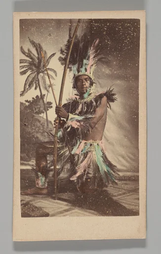 [Studio Portrait: Indigenous Man Seated Holding Bow]