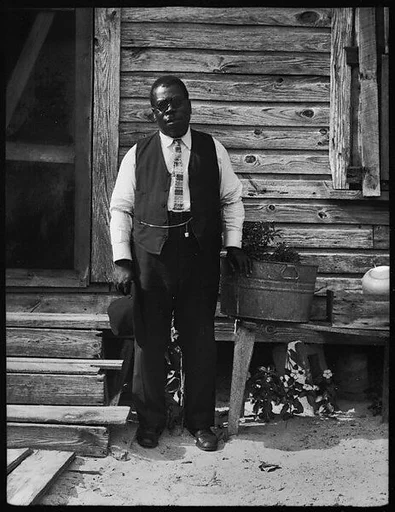 [Man Wearing Rounded Spectacles Outside House, Florida]