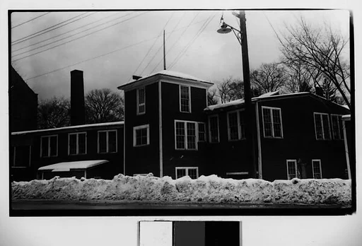 [Wooden Clapboard Building Behind Snow Bank]