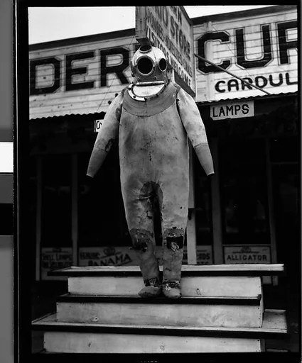 [Sponge Diver's Suit in Front of Modern Curio Store, Tarpon Springs, Florida]