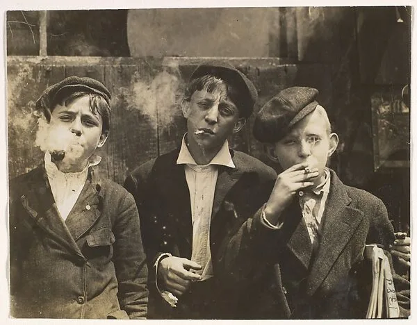 11:00 A.M. Monday, May 9th, 1910. Newsies at Skeeter's Branch, Jefferson near Franklin. They were all smoking. Location: St. Louis, Missouri. — Lewis Hine