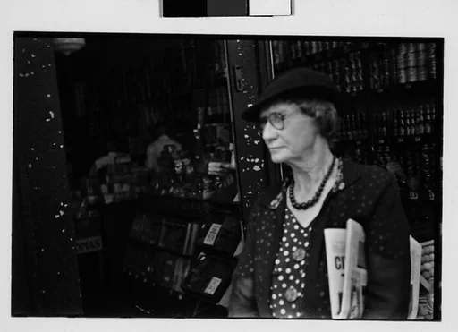 [Two 35mm Film Frames: Old Woman Outside Main Street Grocery Store, Ossining, New York]