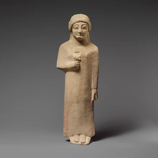 Limestone statuette of a female votary holding a flower