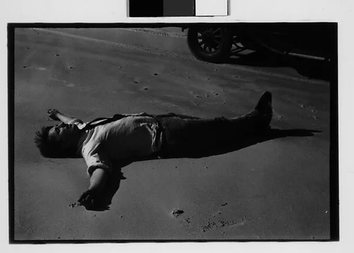 [Two 35mm Film Frames: Peter Sekaer Lying on Sand, Louisiana or Mississippi]