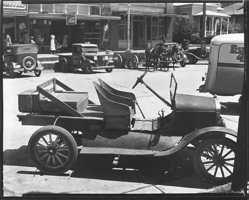 [Street Scene with Parked Cars, Mule-Drawn Wagon, and Bucket Seat Model T Ford in Foreground, Marion, Alabama]