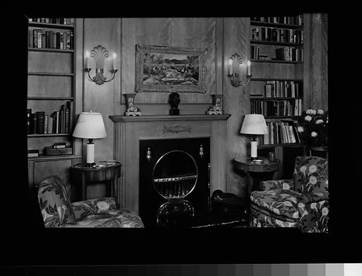 [Library Interior Showing Fireplace with Adjacent Bookshelfs and Armchairs]