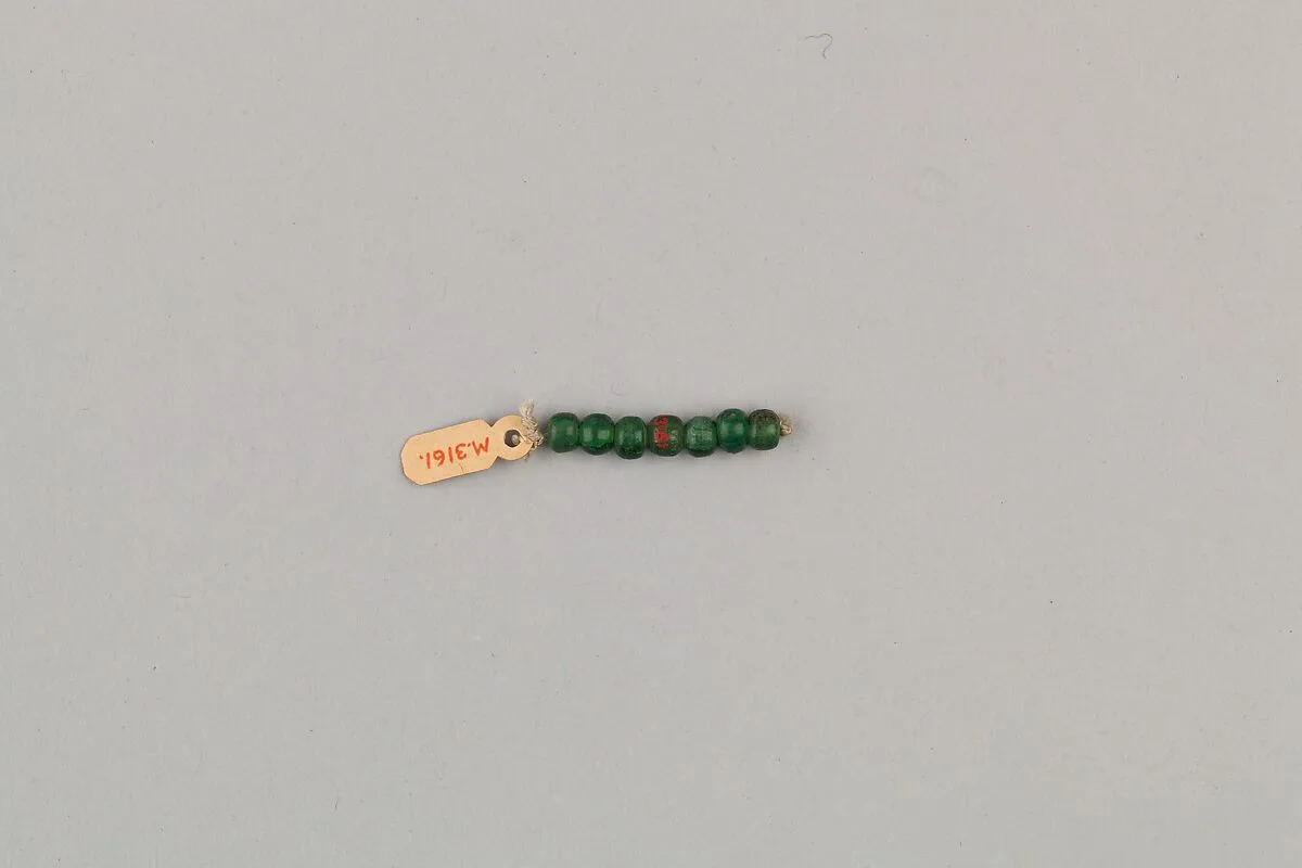 String of 7 elongated disc beads — Unknown