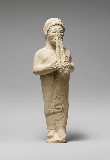 Limestone statuette of a flute-player