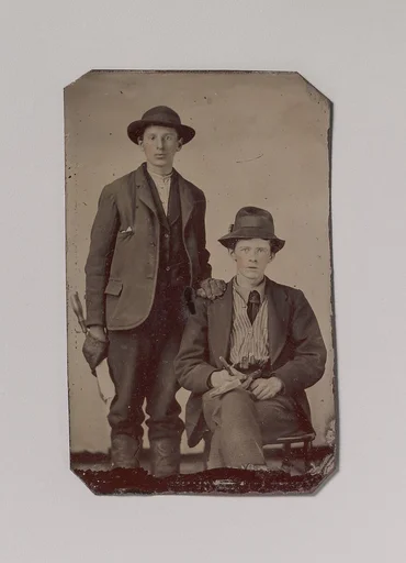 [Two Young Men, One Seated and One Standing, Holding Carpentry Tools]