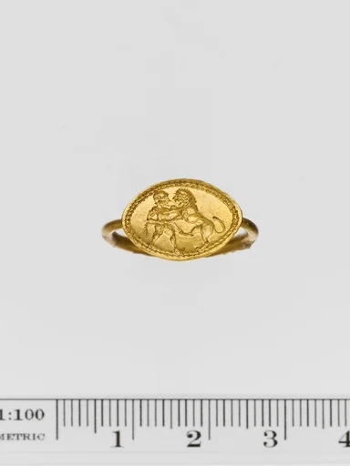 Gold ring engraved with a warrior and a lion