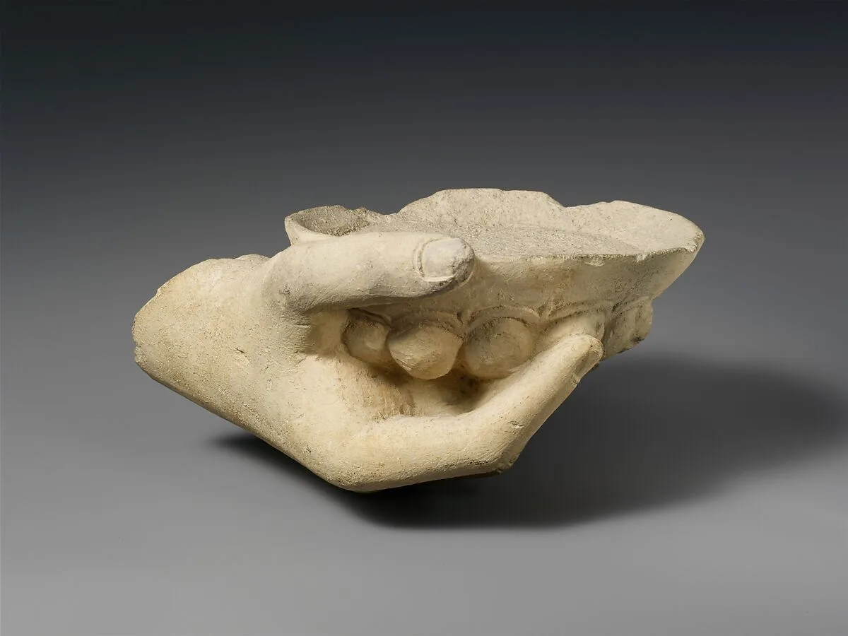 Limestone statue fragment of a right hand holding a phiale (libation bowl) — Unknown