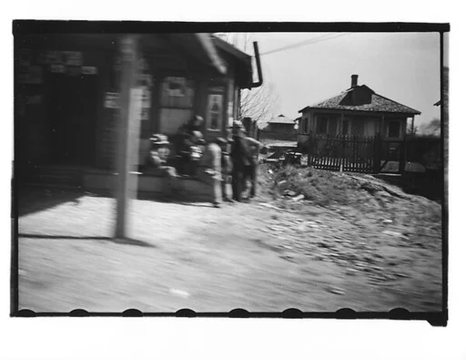 [Group of Men Outside Roadside Stand, From Moving Automobile, Louisiana]