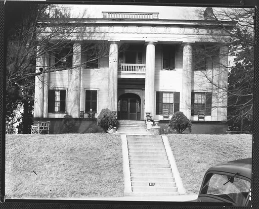 [Greek Revival House with Ornamental Friezework and Man Seated on Porch, Macon, Georgia]