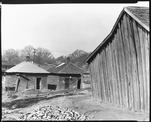 [Wooden Houses with Pile of Bricks in Foreground, Tupelo, Mississippi]