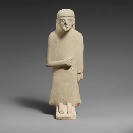 Limestone statuette of a male votary with a long garment and a plain headdress