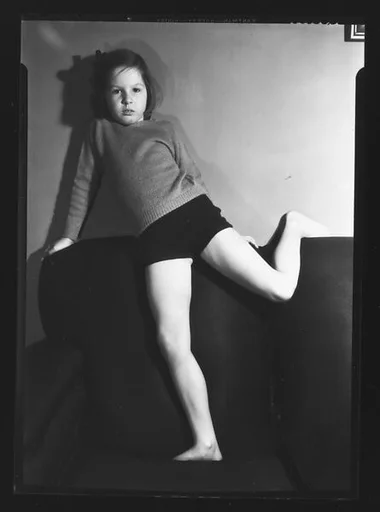 [Unidentified Young Girl with Leg Draped Over Sofa]