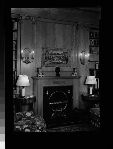 [Library Interior Showing Fireplace with Adjacent Bookshelfs and Armchairs]