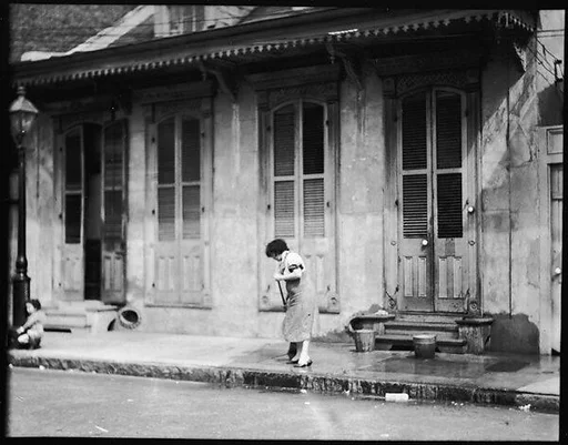 [Woman Outside Shuttered House, New Orleans, Louisiana]