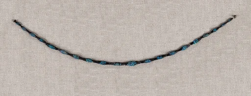 String of black faience beads with encrustations