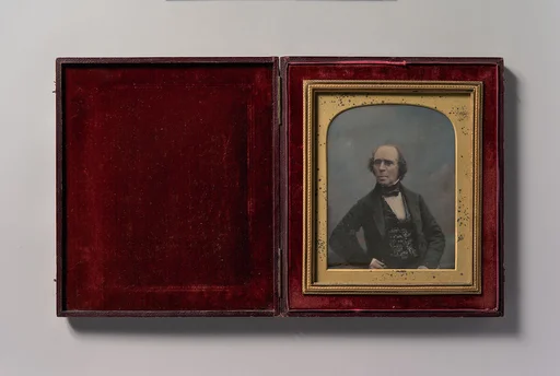 [Middle-aged Man with Glasses Holding Pocket Watch]