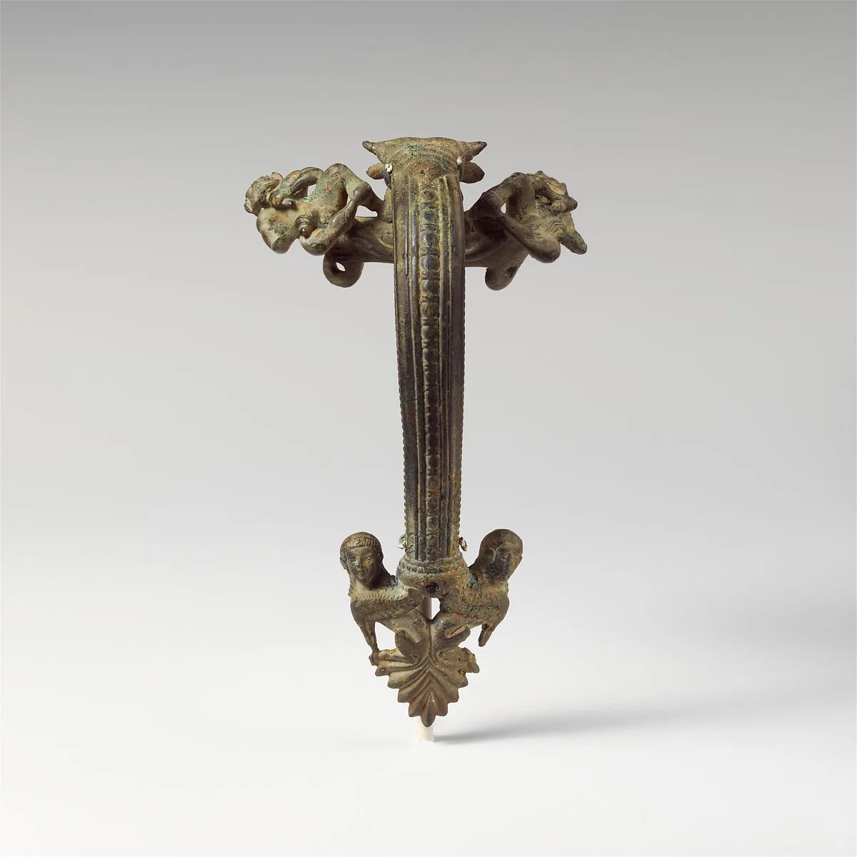 Bronze oinochoe (jug) handle with satyrs flanking a head of Acheloos — Unknown