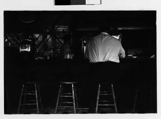 [Two 35mm Film Frames: Man Seated at Bar, From Behind, and Group in Doorway of Shopfront with Sale Signs in Window, New York City]