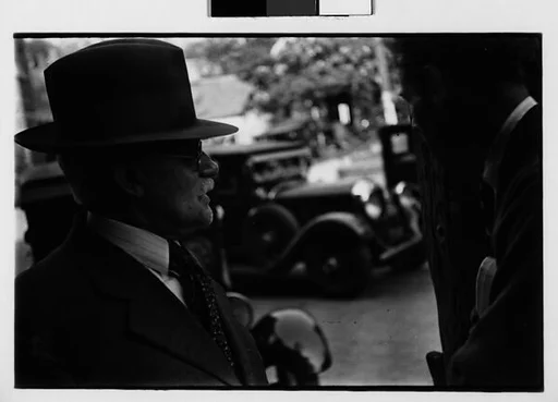 [Two 35mm Film Frames: Man Wearing Hat with Car in Background]