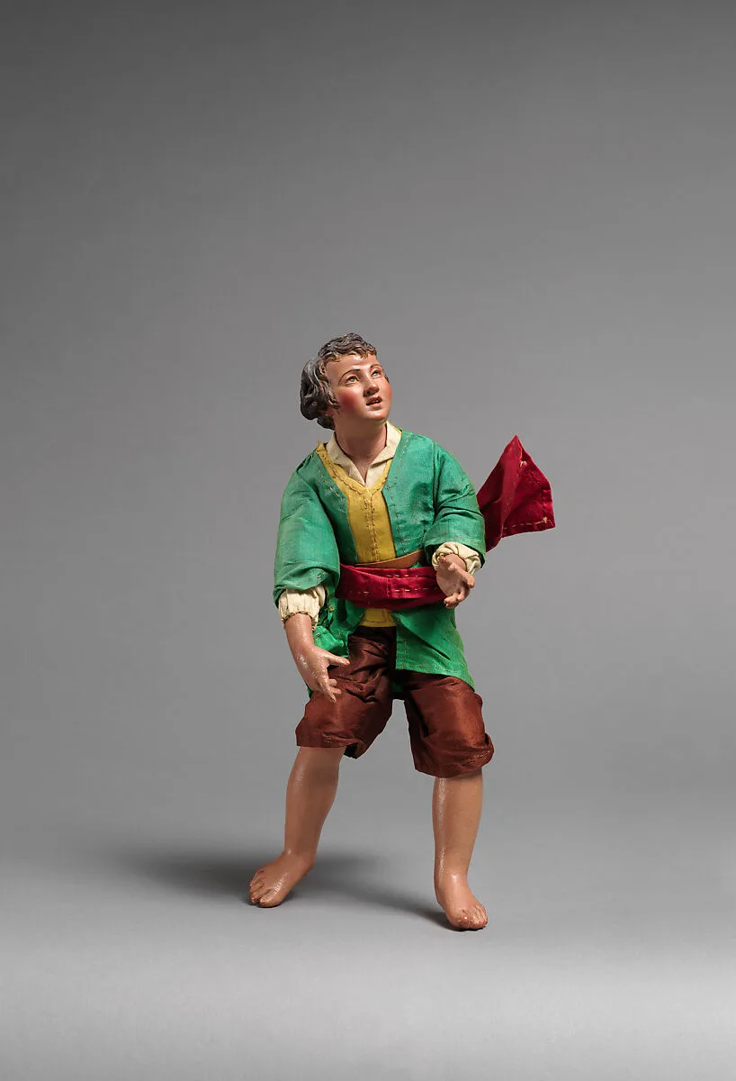 Boy in green shirt, brown pants, red sash — Unknown