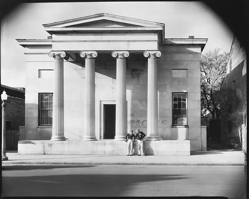 [Greek Revival Building with "SIGNS" Painted on Façade and Two Men Talking on Street, Natchez, Mississippi]