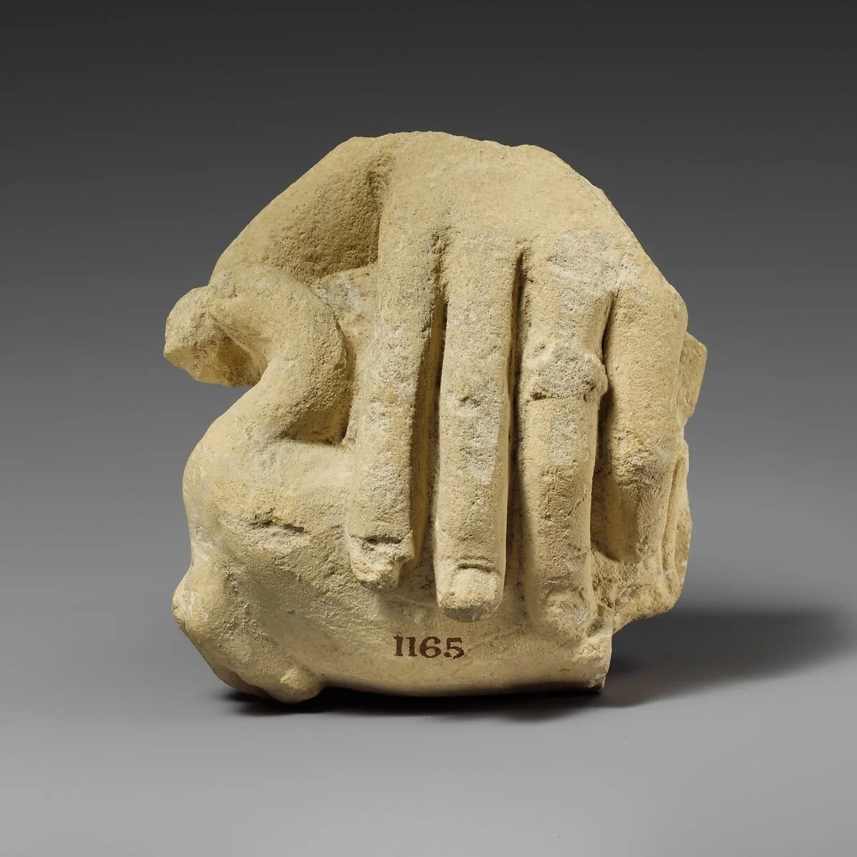 Limestone hand holding a bird — Unknown