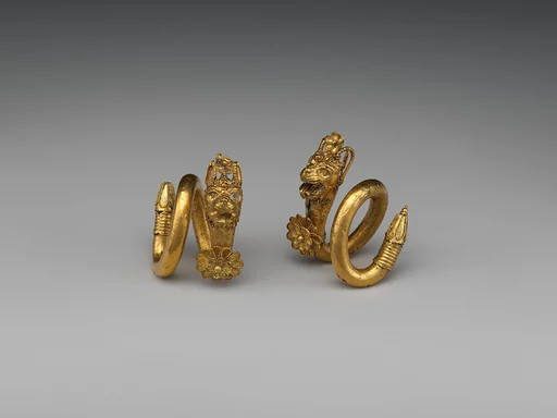 Gold and copper alloy spiral earring with lion-griffin head terminal