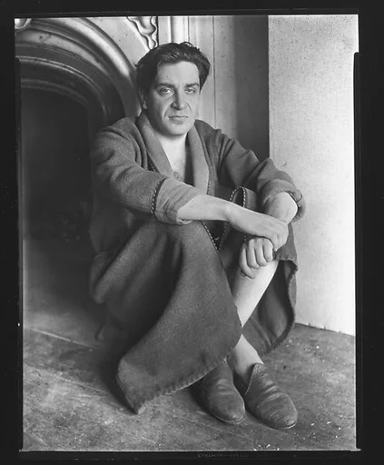 [Reuben Nakian Seated Against Fireplace Mantle]