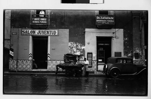[Fruit Vendor's Cart and Parked Car in Front of Salon Juventud, Havana]