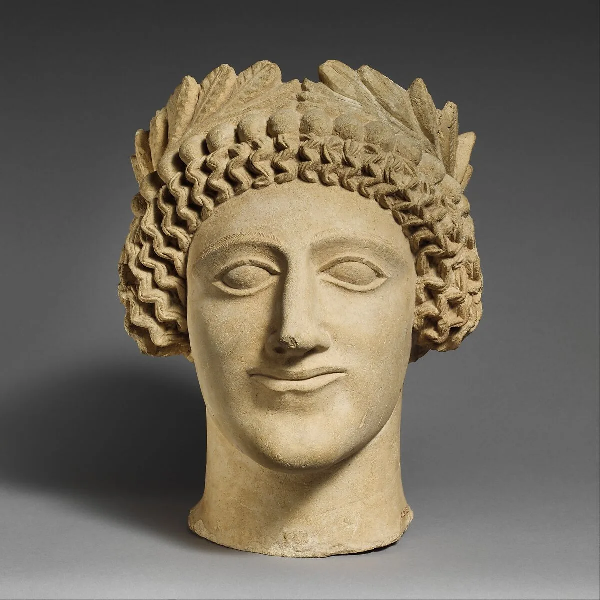 Limestone head of a youth with wreath — Unknown