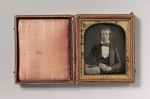 [Seated Young Man Resting Arm on Table Beside Daguerreotype Case]