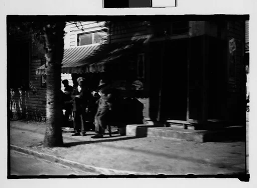 [Men Outside Corner Store, From Moving Automobile, Savannah, Georgia]