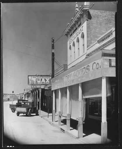 [Oblique View of Main Street Shopfronts and Parked Cars, Morgan City, Louisiana]