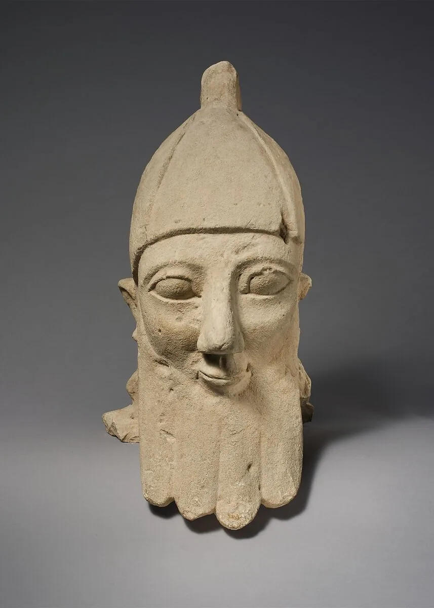 Over-lifesize bearded head wearing a conical helmet — Unknown