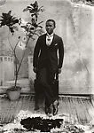 Young man in cravat with potted plant — Alex Agbaglo Acolatse