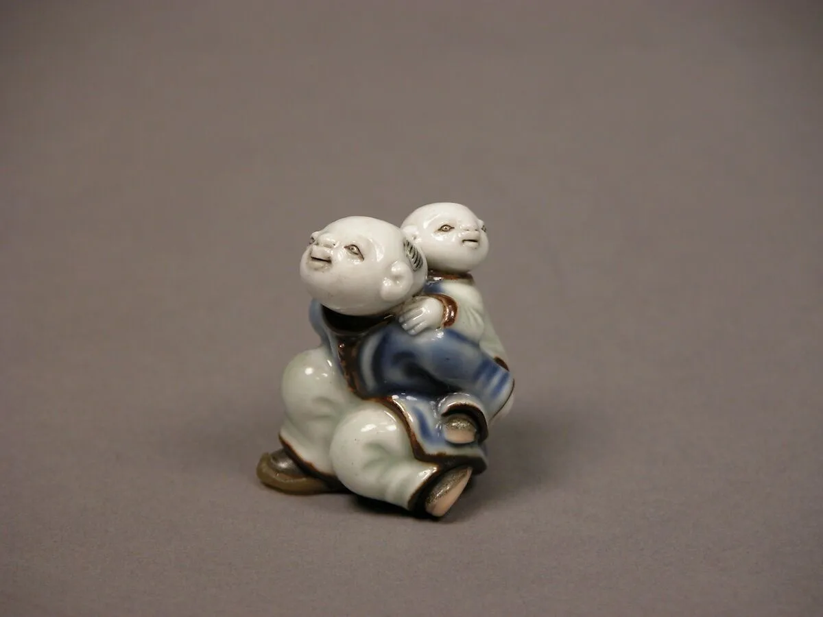 染付子運び唐子形根付|Child Carrying an Infant Netsuke — Unknown