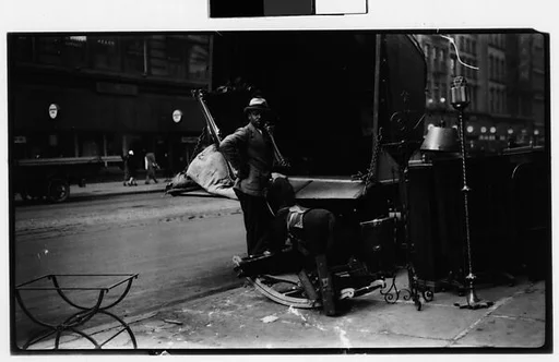 [Open Cab of Moving Truck on Street with Mirror, Hobby Horse, and Man in Foreground, New York City]