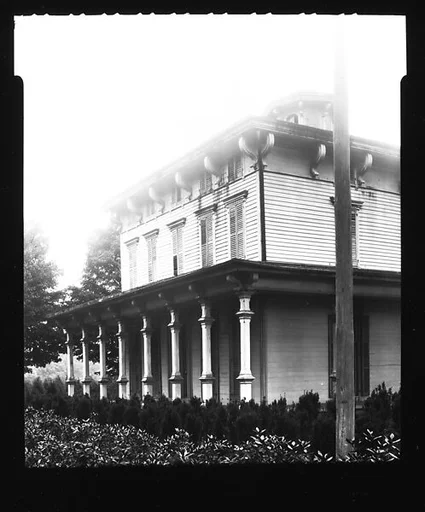 [Oblique View of House with Full-Façade Porch and Telephone Pole in Foreground (Overexposed)]