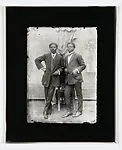 Two dapper young men leaning on a chair — Alex Agbaglo Acolatse