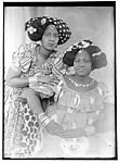 Two women with classic two-lobed coiffure, fancy head cloths