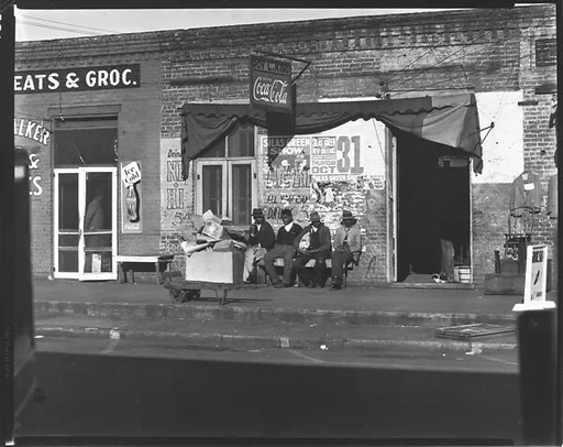 [Men Seated on Bench on Sidewalk, Selma, Alabama]