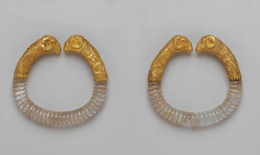 Pair of bracelets with rock crystal hoops and gold rams' heads
